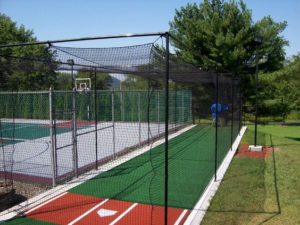 batting cage next to basketball court