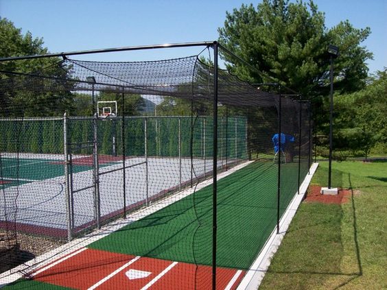 batting cage next to basketball court
