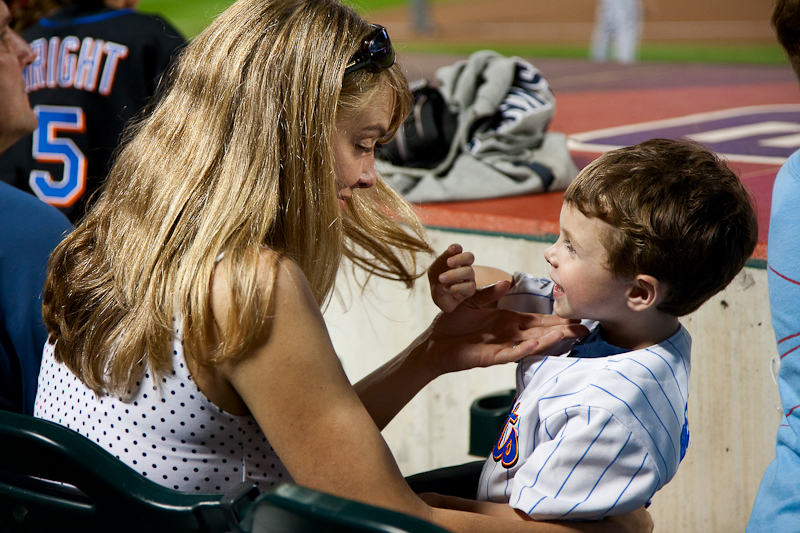 mom helping young baseball player