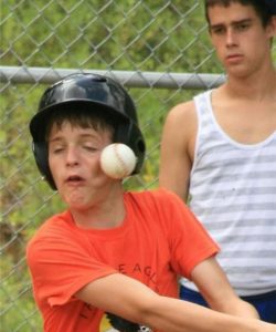 boy getting hit in the face with baseball