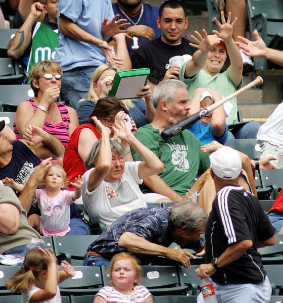 man getting hit in face with bat at game