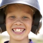 smiling boy in baseball helmet