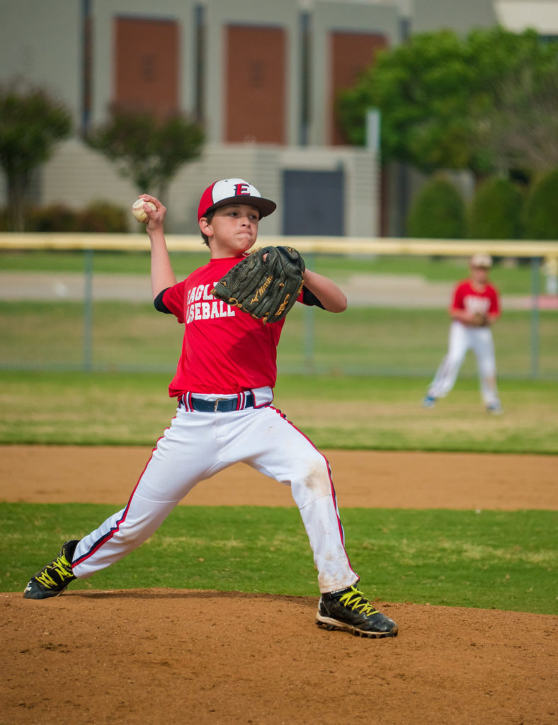 youth pitcher in red jersey