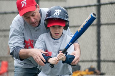 coach helping with bat grip